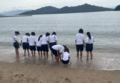 足だけ海に入って楽しむ生徒たち