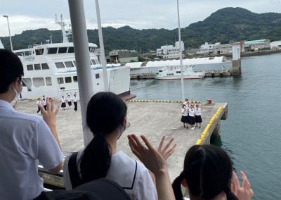 港で手を利降り合って別れる生徒たち