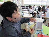 折り紙を貼って作品を作っている児童