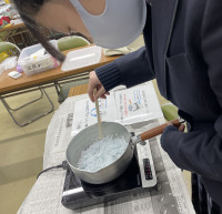 鍋に入れたろうを溶かす生徒