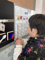 カレンダーを触り、今日のシールを見付けている児童