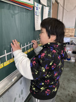 黒板に貼ってある数直線を触り、今日の日付まで移動する児童