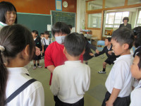 ２年３組の児童とかごめかごめをしながら言葉を交わす児童。