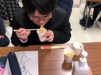 水で作った非常食のラーメンを食べる男子生徒