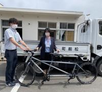 校長先生と松前町の職員さんがタンデム自転車を前に記念撮影