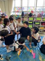 みどり小1年生の児童と握手をする本校小学部1年生。笹飾りをつける場面。