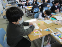カレンダーを触り、ハサミで切った折り紙を貼る場所を考えている本校児童