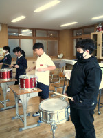 合奏でスネアドラムを叩く児童