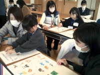 参加者２名がイラストを紙に貼って、ビンゴのカードを作っている。