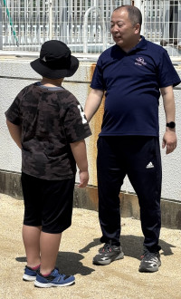 校長と児童がグランドでサッカー